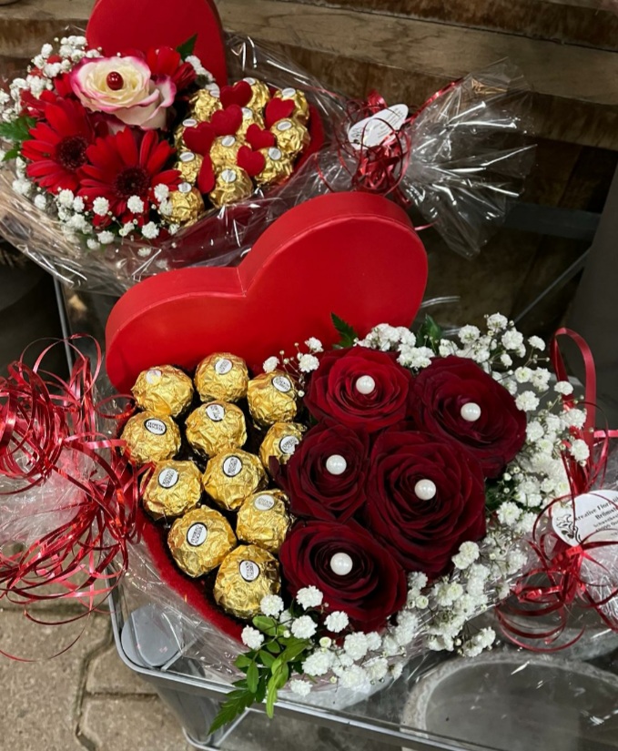 Herzförmige Geschenkboxen mit roten Rosen, Gerbera und Ferrero Rocher